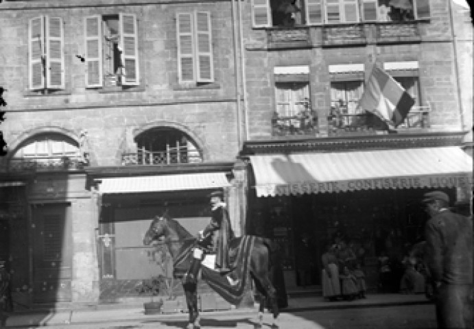 Un homme costumé sur un cheval devant une pâtisserie confiserie