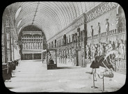 Reproduction d'une vue de la salle des preuses du château de Pierrefonds, une collection d'armures est exposée.