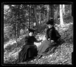 Emilie Vuillaume et une femme plus âgée assises dans un bois.