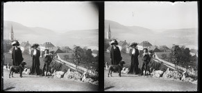 Emilie Vuillaume, épouse d'Elisée Coutemoine, accompagnée de son caniche, d'une jeune femme et d'un petit garçon, un village en arrière-plan.