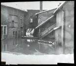 Reproduction d'une vue de Morteau inondée, une barque se trouve dans la cour d'une habitation.