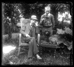 Un homme assis dans un jardin, avec un jeune garçon et le caniche Coquette du docteur Elisée Coutemoine.