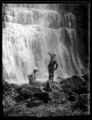Cascades du Hérisson, un trio de jeunes gens au bas de la cascade de l'Éventail, un jeune homme désigne la cascade.