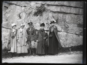 Quatre femmes et un officier du 165e bataillon canadien au pied d'une paroi rocheuse.