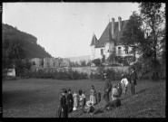 Le château de Chalain. Quinze personnes dans un champ devant le château de Chalain