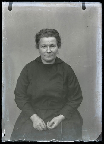 Portrait d'une femme assise portant une robe noire.