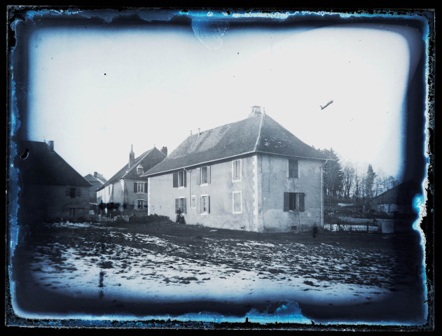 Deux femmes posent devant une maison, un peu de neige recouvre le sol.