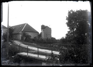 Ruines d'une tour du château et bâtiment de la ferme du Parc à Vers-en-Montagne, vue prise au niveau de la passerelle sur l'Angillon.