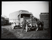 Exploitation de la forêt de la Joux par les soldats canadiens : quatre militaires posant avec un camion, des planches de bois en arrière-plan.