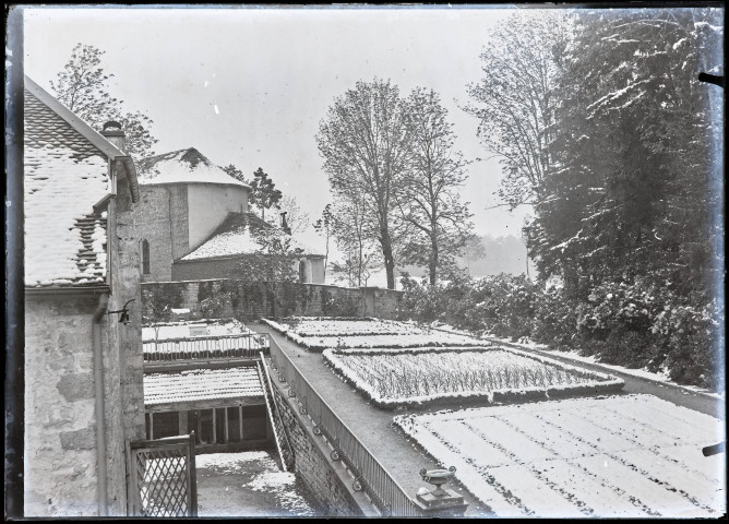 Bâtiments et potager sous une fine couche de neige à Vers-en-Montagne.