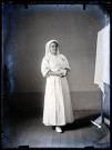 Portrait d'une infirmière debout, un livre dans les mains.