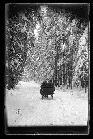 Paysage de neige, deux personnes en traîneau vues de dos.