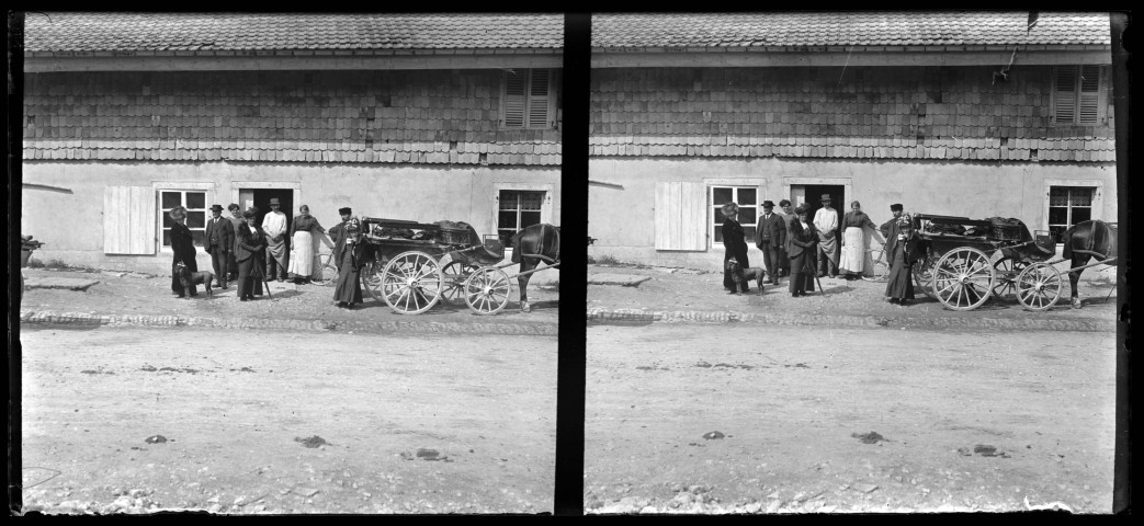 Personnes avec un chien à côté d'une voiture attelée devant une maison de la Chaux-de-Gilley, au haut du mur recouvert d'un assemblage de tuiles posées à la manière traditionnelle des tavaillons en bois.