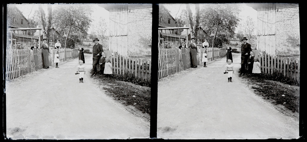 Groupe avec enfants sur le chemin entre deux maisons.