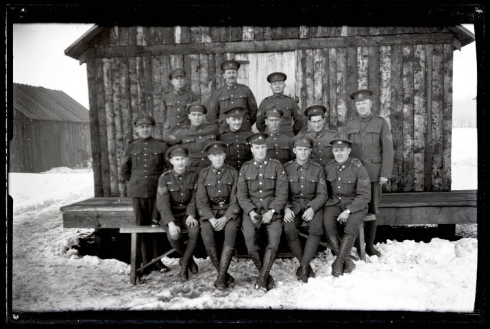 Portraits du Corps des forestiers canadiens et autres troupes : groupe de militaires en uniforme posant devant un baraquement en bois en hiver.