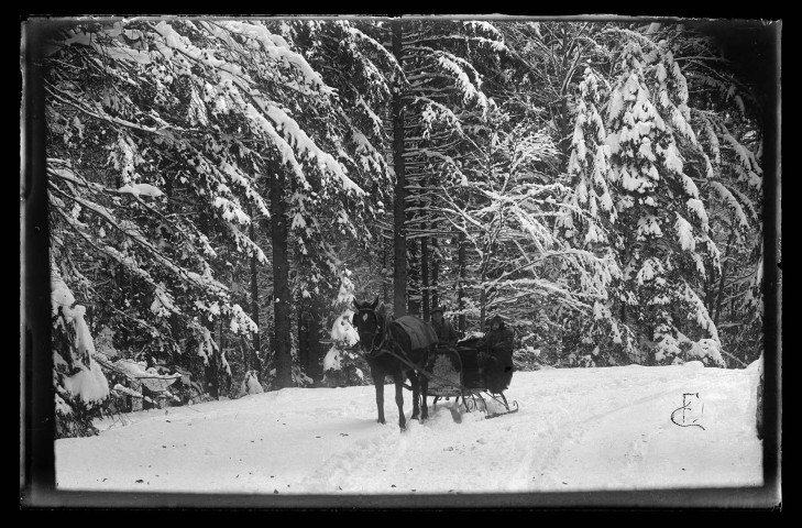 Paysage de neige, deux personnes en traîneau tiré par un cheval.