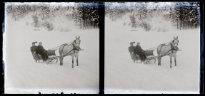 Paysage de neige, un homme et une femme dans un traîneau tiré par un cheval.