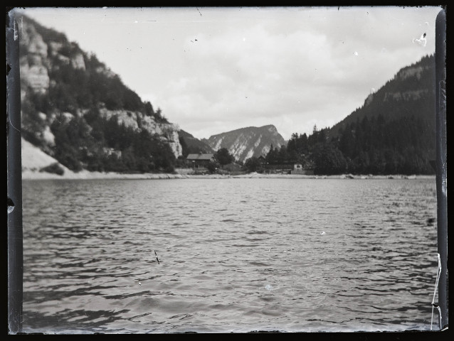 Lac encaissé, des habitations au loin.