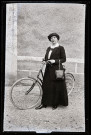 Portrait de jeune femme élégante avec bicyclette et sac à main en cuir.