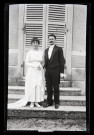 Portrait d'un couple de mariés posant sur les marches d'un bâtiment.