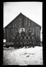 Portraits du Corps des forestiers canadiens et autres troupes : groupe de militaires en uniforme posant dans la neige devant un baraquement en bois.