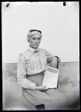 Portrait d'Agathe Coutemoine assise montrant un numéro du journal "Photo-revue".