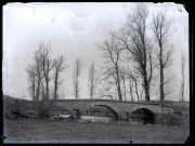 Pont du Latet enjambant l'Angillon à Vers-en-Montagne, de grands arbres en arrière-plan.
