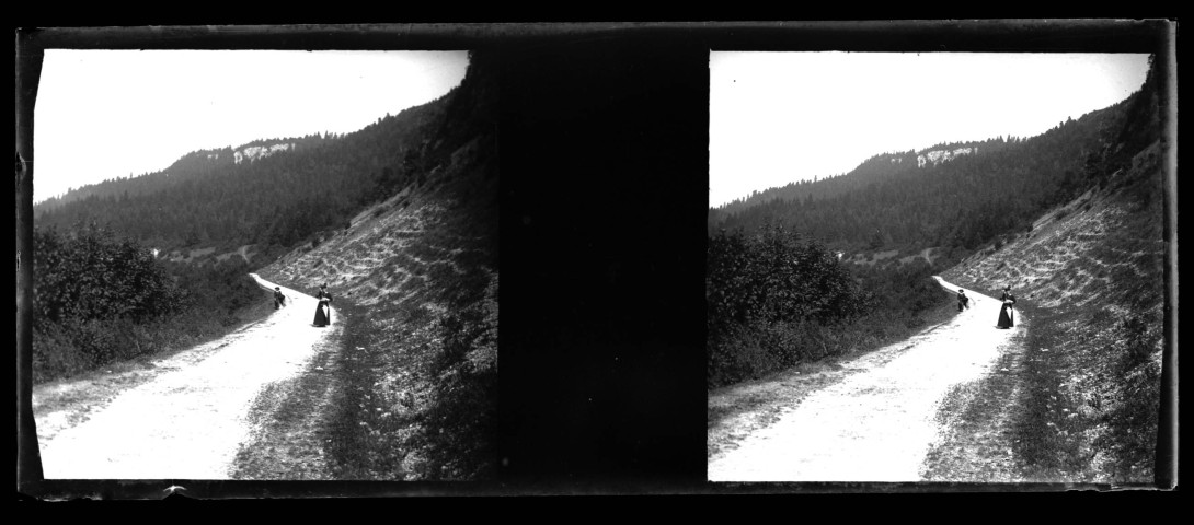Paysage vallonné près de Champagnole, deux femmes marchent sur la route.