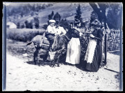 Petit garçon sur un âne à côté de trois femmes.
