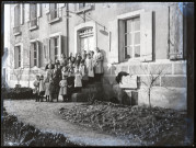 Groupe de petites filles sur les marches d'un bâtiment, en compagnie du lieutenant Ritchie du Corps des forestiers canadiens.