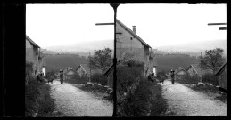 Vue d'un village du Doubs, deux personnes et un chien dans une rue.
