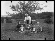 Groupe d'adultes et d'enfants assis dans l'herbe. Mathilde Coutemoine, debout, verse à boire ; son époux, le comte de Pagnoz, est assis à droite.