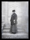 Portrait d'Agathe Coutemoine tenant un journal, sur les marches du pensionnat de jeunes filles rue du Tatet à Vers-en-Montagne.