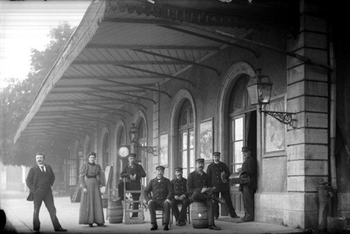 Huit agents des chemins de fer devant la gare