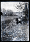 Deux hommes et une femme sur un chemin le long d'un bois.