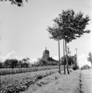 Vue centrée sur l'entrée d'un village avec le clocher.