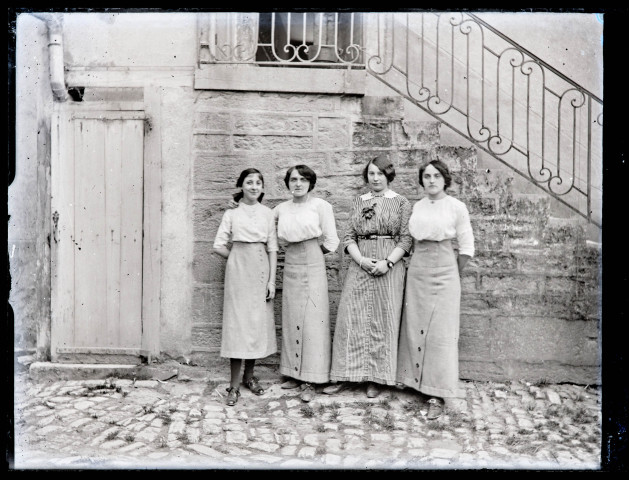 Portrait de quatre femmes au pied d'un escalier (Agathe Rameaux en robe rayée).