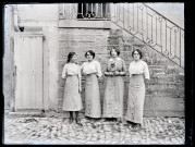 Portrait de quatre femmes au pied d'un escalier (Agathe Rameaux en robe rayée).