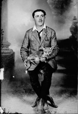 Un homme posant avec un renard sauvage