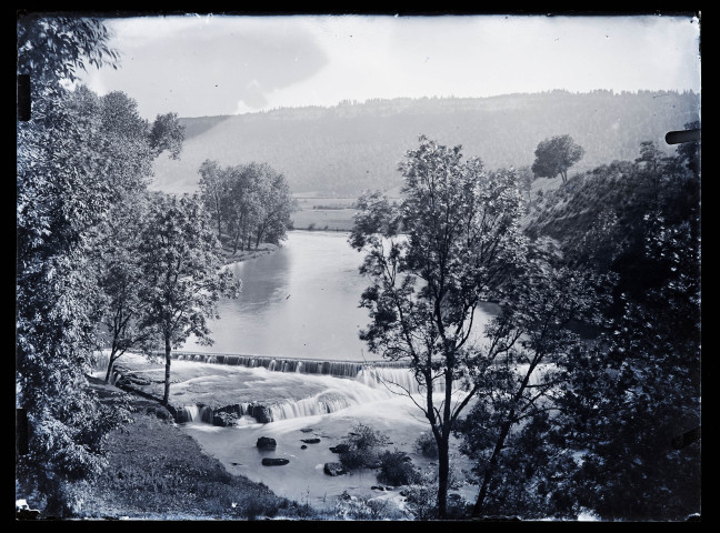 Paysage avec étendue d'eau aboutissant sur une cascade artificielle.