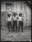 Portraits du Corps des forestiers canadiens et autres troupes : trois militaires posant devant un baraquement en bois.