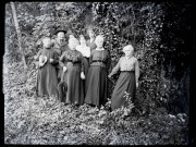 Six femmes (dont Mathilde Coutemoine, 2e à partir de la droite), un prêtre et un militaire posent dans la nature, le militaire porte le rabat et le chapeau du prêtre.
