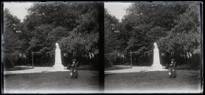 Femme dans un parc, près d'un buste sur un piédestal.