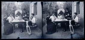 Trois femmes et trois hommes attablés avec une boisson dans un jardin devant une maison.