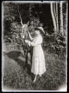 Portrait d'une femme tenant un cheval par les rênes.