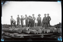 Exploitation de la forêt de la Joux par les soldats canadiens : bucherons militaires posant sur une pile de troncs d'arbres.