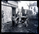 Homme et enfant utilisant une scie à ruban pour débiter des buches de bois.