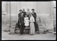 Famille posant sur les marches d'un bâtiment, Agathe Coutemoine au dernier rang.