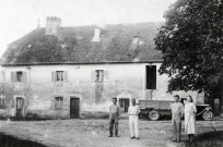 La Ferté (Jura), le Moulin en 1936. Façade du bâtiment, un camion et quatre personnages. Genlis (21), Optique Sociale.