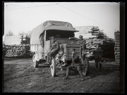 Exploitation de la forêt de la Joux par les soldats canadiens : quatre militaires posant avec un camion, des planches de bois en arrière-plan.